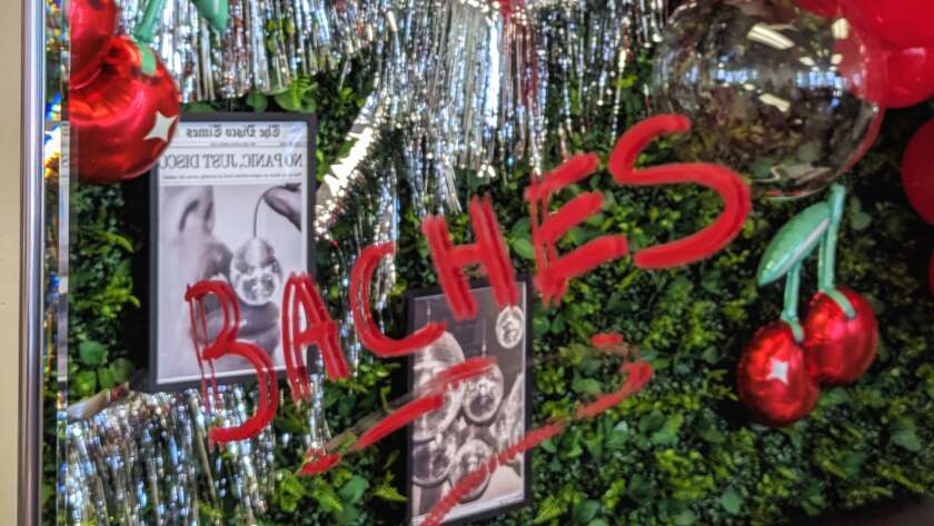A mirror reflection of a Fete Events backdrop by Melissa Burgio of Fete Events and Bad Baches. Baches is written in red lipstick on the mirror, showcasing the playfulness of this girls night out event