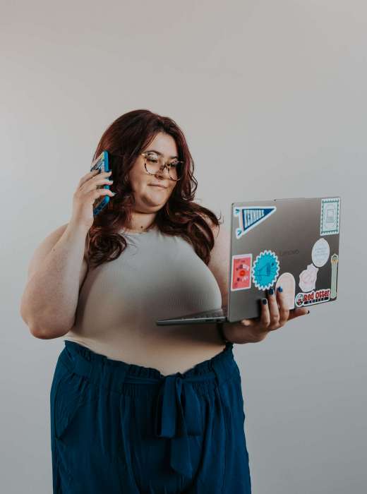 Social media manager working on a laptop while taking a phone call